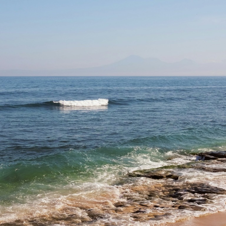 a small white boat in the middle of the ocean